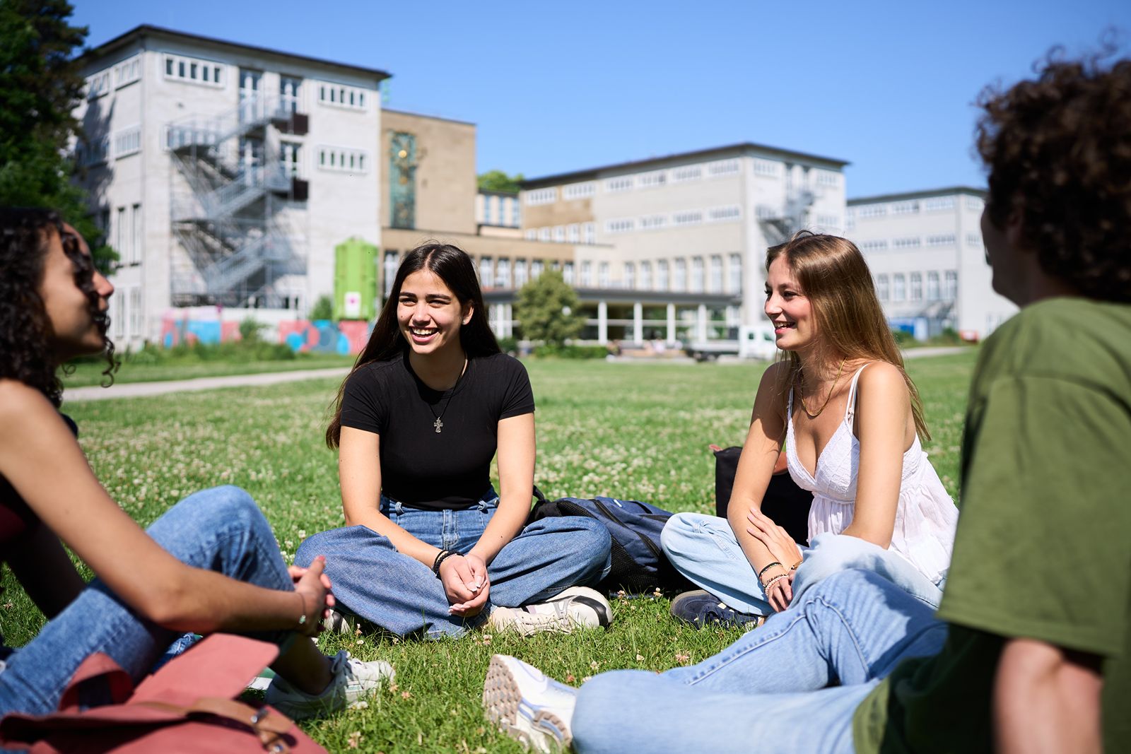 Zielgruppe der Studierenden auf einer Wiese auf dem Campus der Universität zu Köln
